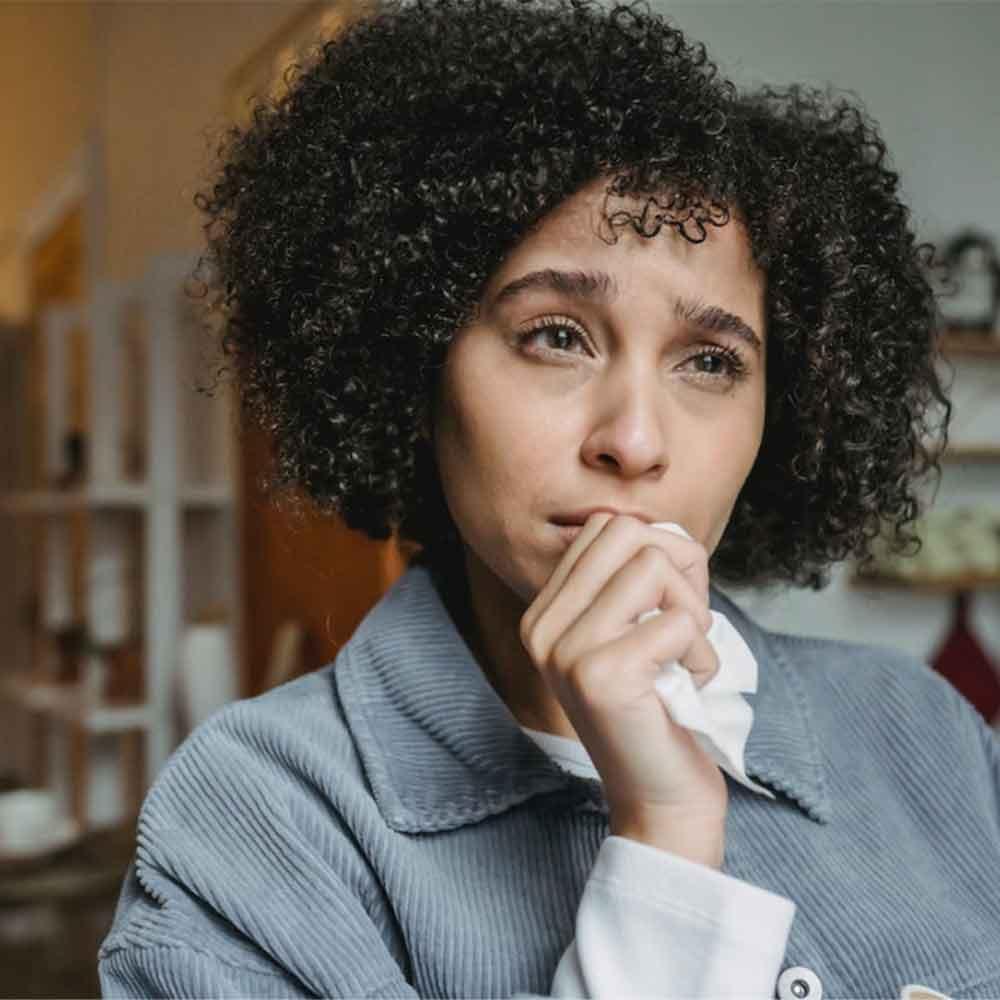 Women with a sad face holding a tissue.